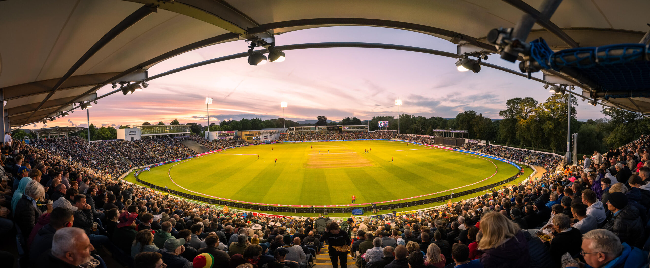 Wide angle image of Sophia Gardens Cricket Grounds with packing stands and players on pitch